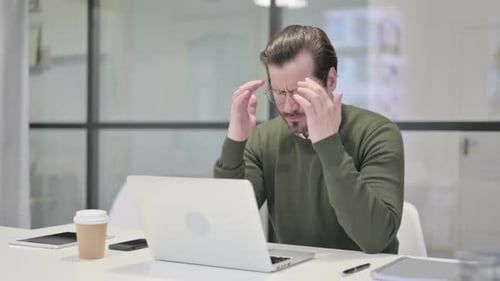 Man Working at Desk Massages Temples