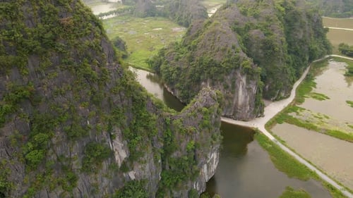 Aerial Shot of Beautiful Limestone Mountains with Passes Carved By a River in Ninh Binh Region a