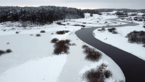 Eine Drohne über einen Fluss im Winter fliegen