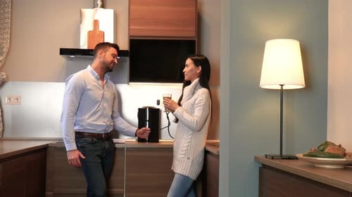 Couple Talking in Modern Kitchen Over Coffee