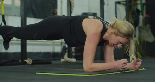Fitness Woman Doing Plank Exercise Workout at Mat in Gym