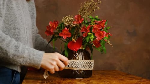 Woman Arranges Flowers With Lace Ribbon At Home