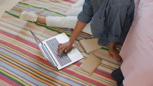 Étudiant utilisant un ordinateur sur le sol