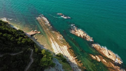 Top View of Rocky Coastline Down Blue Sea Deep White Cliffs