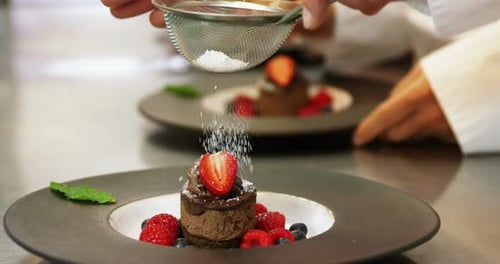 Chef Adding Powdered Sugar to Gourmet Dessert