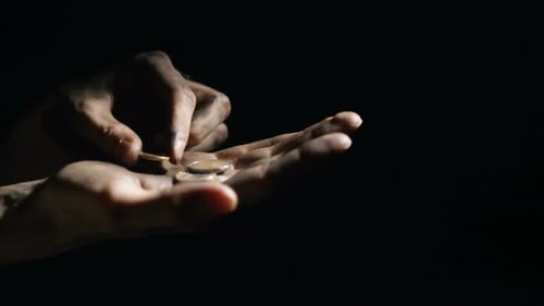 Hands Counting Coins in the Dark