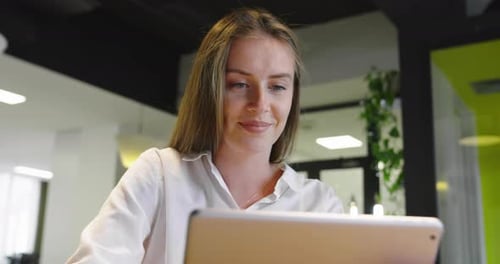 Smiling Startup Businesswoman Using Tablet While Standing in Minimalist Office