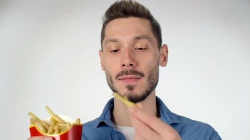 Fröhlicher Mann isst Pommes
