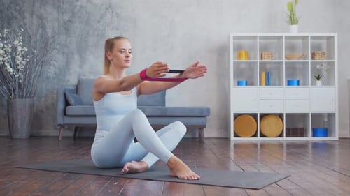 Woman Exercising With Resistance Band At Home