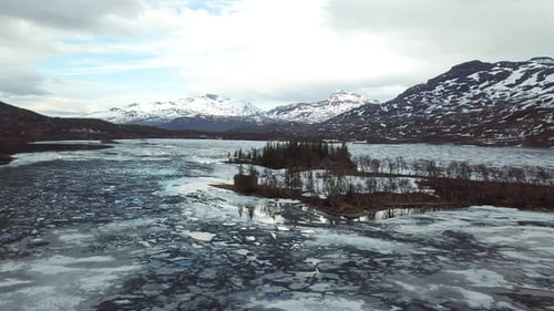 Winter Norwegian landscape with snowy mountains and fjord. Reflection of the mountain in the water.