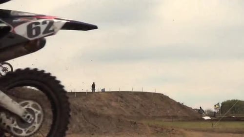 Dirt Bikes Jump Over Hill on Course
