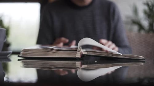 Hombre que pasa las páginas del álbum de fotos