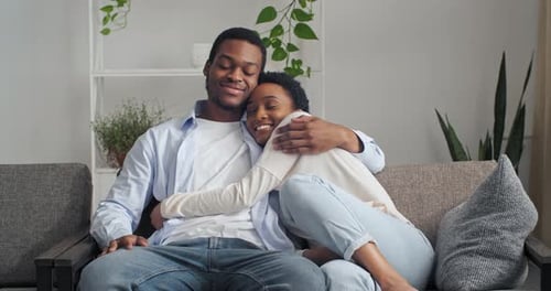 Couple Embracing on Couch Indoors at Home