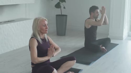 Woman and Man Practicing Yoga at Home