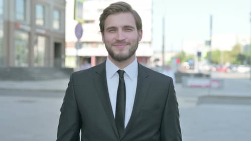 Confident Young Man Smiling Wearing a Suit