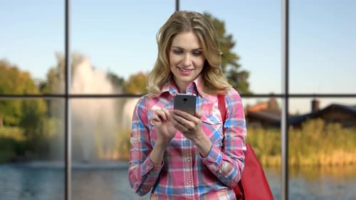 Smiling Woman Texting On Phone Near Lake