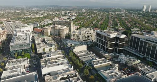 Flying Over the City of Beverly Hills, California, Looking Down at Busy Streets Lined with Palm Tree
