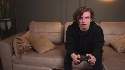 Young Adult Playing Video Game on Couch