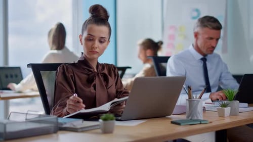 Focused Woman Working on Laptop in Modern Office