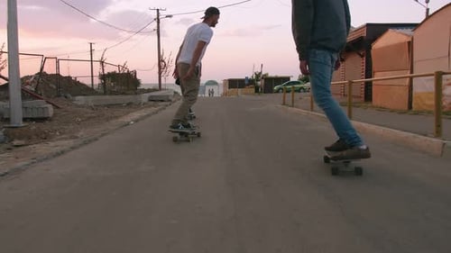 Group of Young People Skateboarding on the Road in the Early Morning Near the Sea Close Up Shot