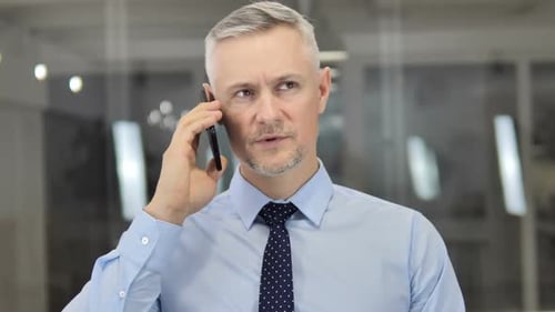 Man in Office Talking on Smartphone