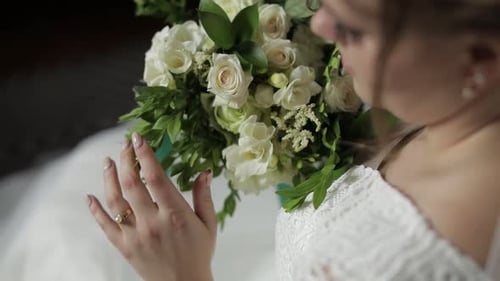 Bride Holds Bouquet of White Roses Close Up