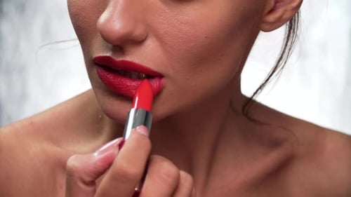 Woman Applies Red Lipstick in Close Up