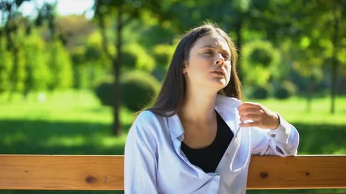 Young Woman Resting on Bench in Park, Suffering From Heat and Stuffiness, Pms