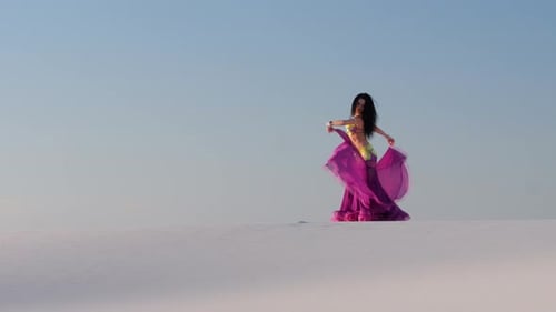 Elegant Woman Belly Dancing in a Desert Landscape