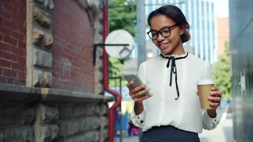 Stylish Woman Walking with Phone and Coffee