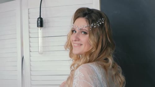 Smiling Woman in White Lace Robe and Headpiece