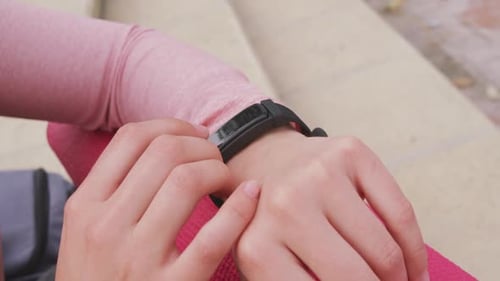 Woman Taps Fitness Tracker Wristband Close Up