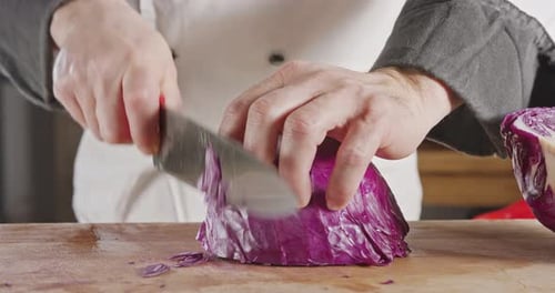 Zeitlupen-Nahaufnahme eines Kochmessers beim Schneiden eines Rotkohls