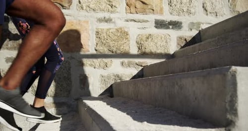 Couple jogging on stairs at beach 4k