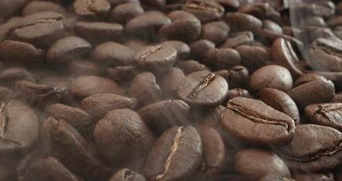 Macro Shot Rösten von Kaffeebohnen Gefilmt in einem dunklen Schlüssel der Rauch, der aus dem Rösten von