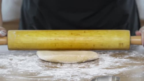 Spreading Dough on Surface with Rolling Pin Close Up