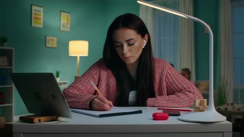 Young Woman Studying at Desk at Night