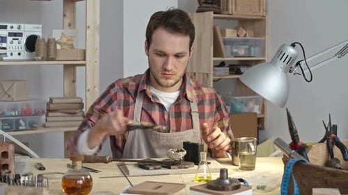 Young Adult Crafts Jewelry in Workshop
