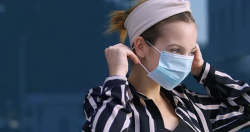 Woman Puts on Mask and Makes OK Gesture