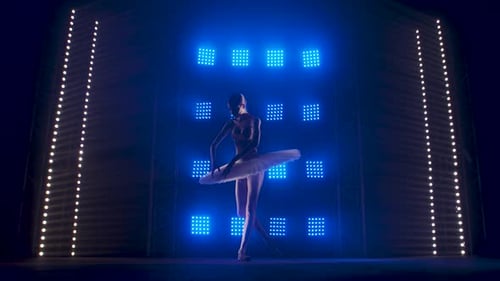 Elegant Ballerina Dancing Gracefully Under Stage Lights