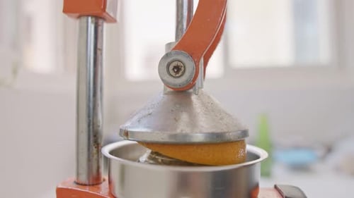 Super slow motion of fresh orange juice squeezed using a manual squeezer