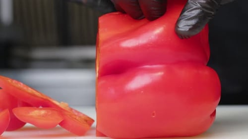 Chef Slicing Fresh Red Bell Pepper with Knife