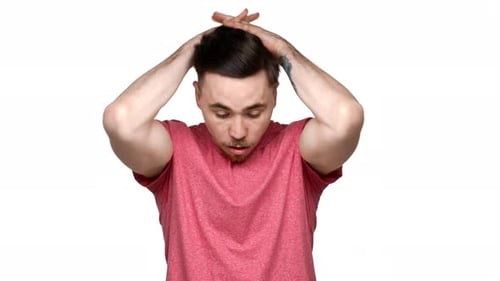 Porträt eines ängstlichen kaukasischen Mannes aus den 20er Jahren, der verwirrt nach dem Kopf greift und Stress oder Entsetzen ausdrückt