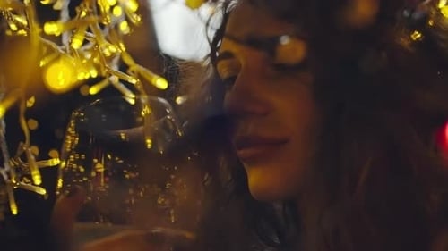 Woman Drinking Wine Surrounded by Festive Lights