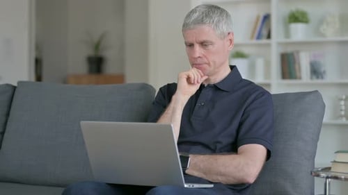 Man Works on Laptop in Home Living Room