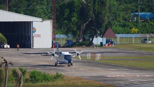 Pequeño avión de transporte rodando desde Hangar