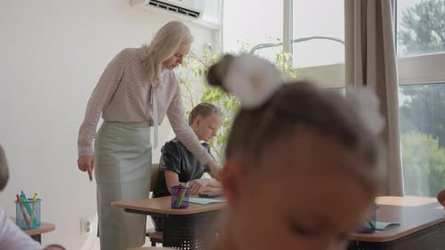 Teacher Guides Children in Classroom Math Lesson