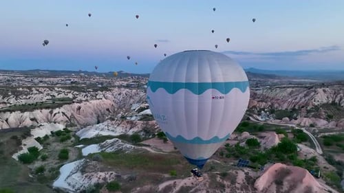 Heißluftballons fliegen über die Berglandschaft von Kappadokien, Türkei.