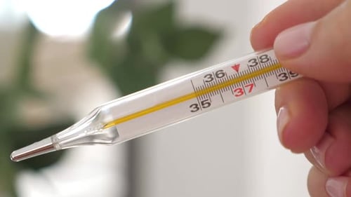 Termômetro com alta temperatura na mão feminina