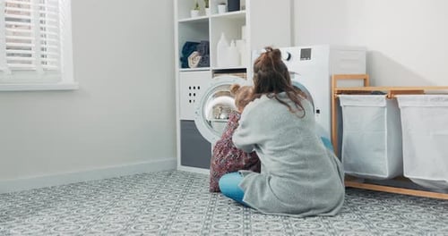 Frau verbringt Zeit mit kleinem Kind in der Waschküche Badezimmer führt Haushaltspflichten bei Mutterschaft aus